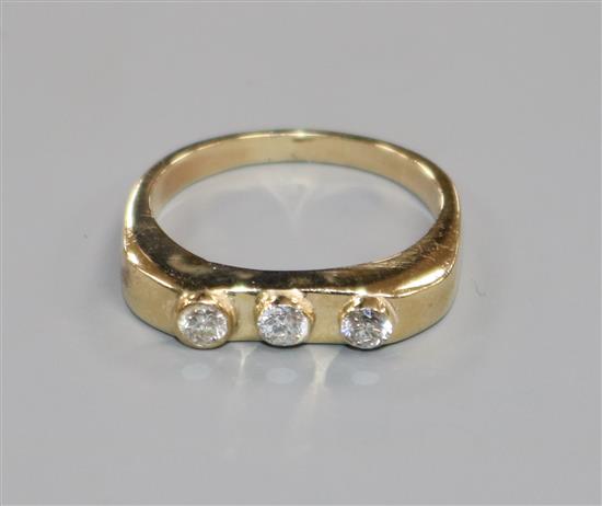 A yellow metal and collet set three stone diamond ring, size P.
